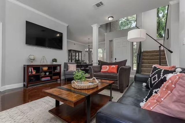 living room with an inviting chandelier, ornamental molding, and ornate columns