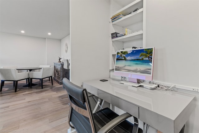 office featuring built in desk and light hardwood / wood-style floors