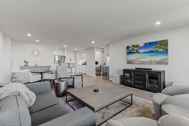 living room with beverage cooler and light wood-type flooring