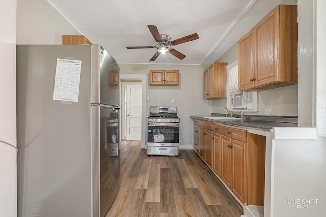 kitchen featuring stainless steel appliances, hardwood / wood-style flooring, sink, and ceiling fan