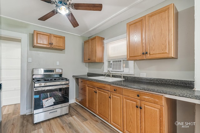 kitchen featuring sink, light hardwood / wood-style flooring, gas stove, and ceiling fan