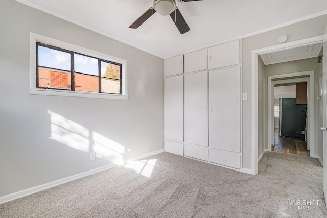 unfurnished bedroom featuring stainless steel fridge, ornamental molding, ceiling fan, light carpet, and a closet