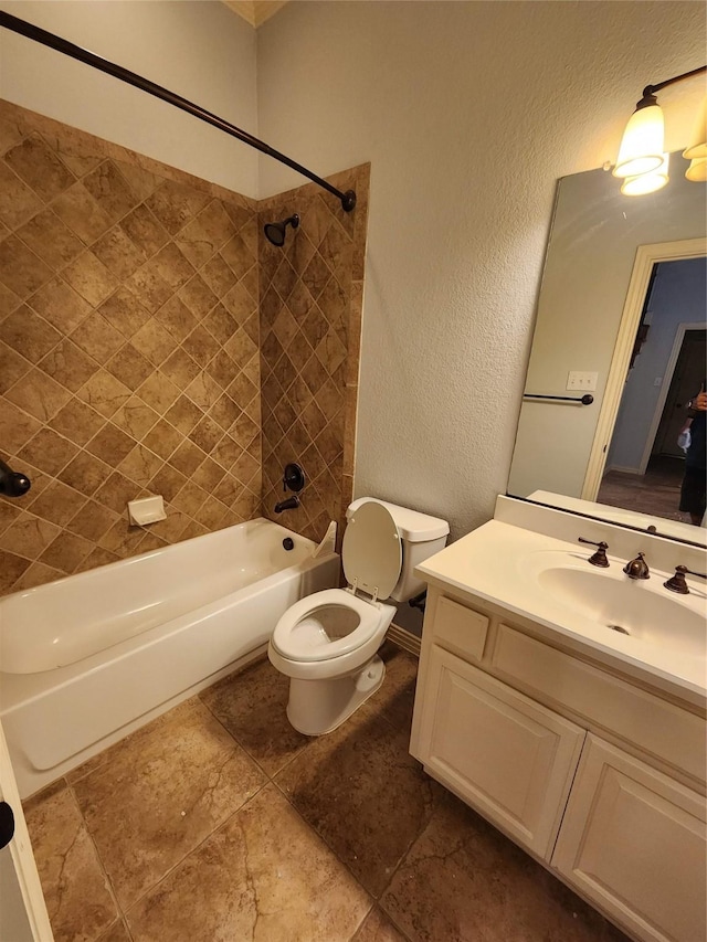 full bathroom featuring tiled shower / bath combo, vanity, and toilet