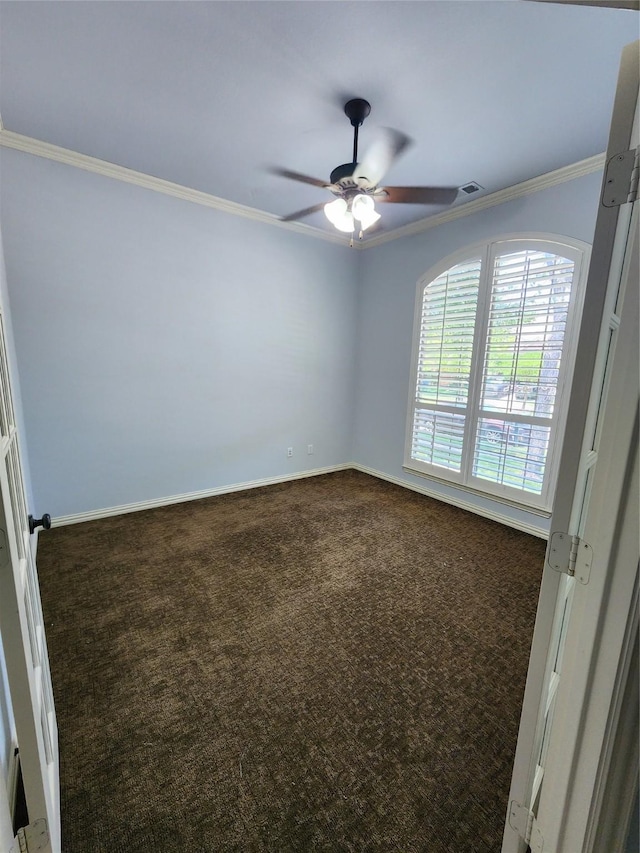 unfurnished room with crown molding, ceiling fan, and dark colored carpet