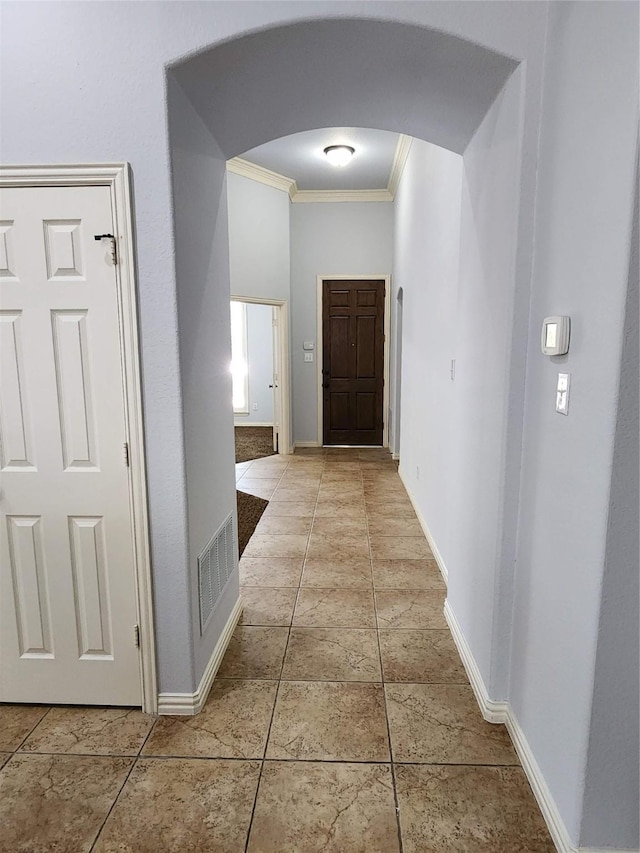 hallway featuring tile patterned floors and ornamental molding