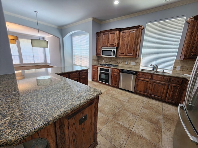 kitchen with tasteful backsplash, sink, ornamental molding, and stainless steel appliances