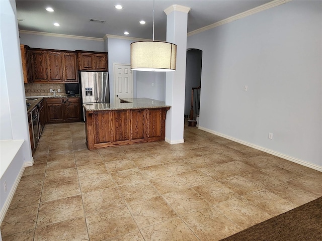 kitchen featuring decorative light fixtures, stainless steel fridge, backsplash, crown molding, and light stone countertops