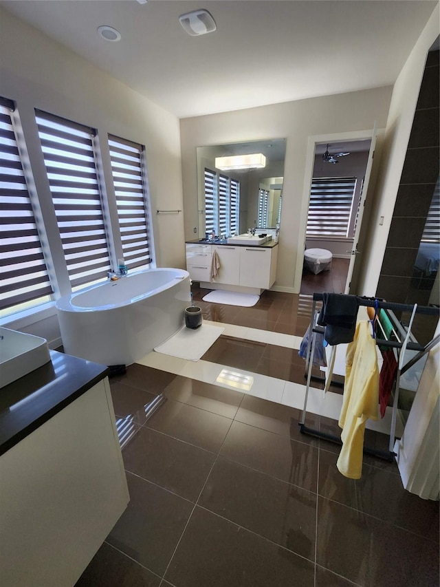 bathroom featuring vanity, a wall unit AC, tile patterned floors, and a bathing tub