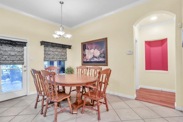 dining area featuring light tile patterned floors, crown molding, and a chandelier