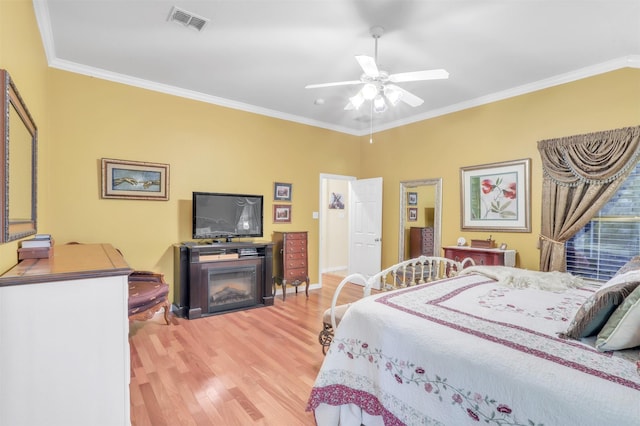 bedroom with crown molding, hardwood / wood-style flooring, and ceiling fan