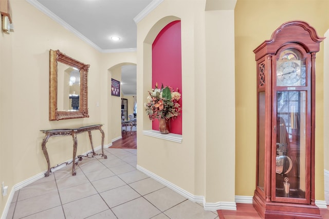 hall featuring ornamental molding and light tile patterned floors