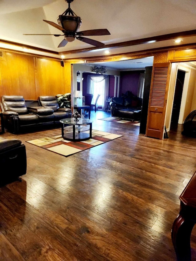 living room with crown molding, dark wood-type flooring, and ceiling fan