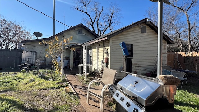 back of property with central AC unit and a pergola