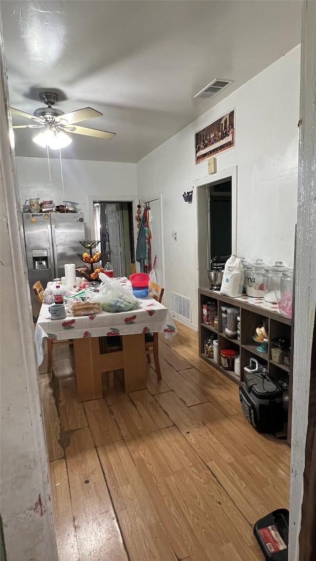 dining area with ceiling fan and wood-type flooring