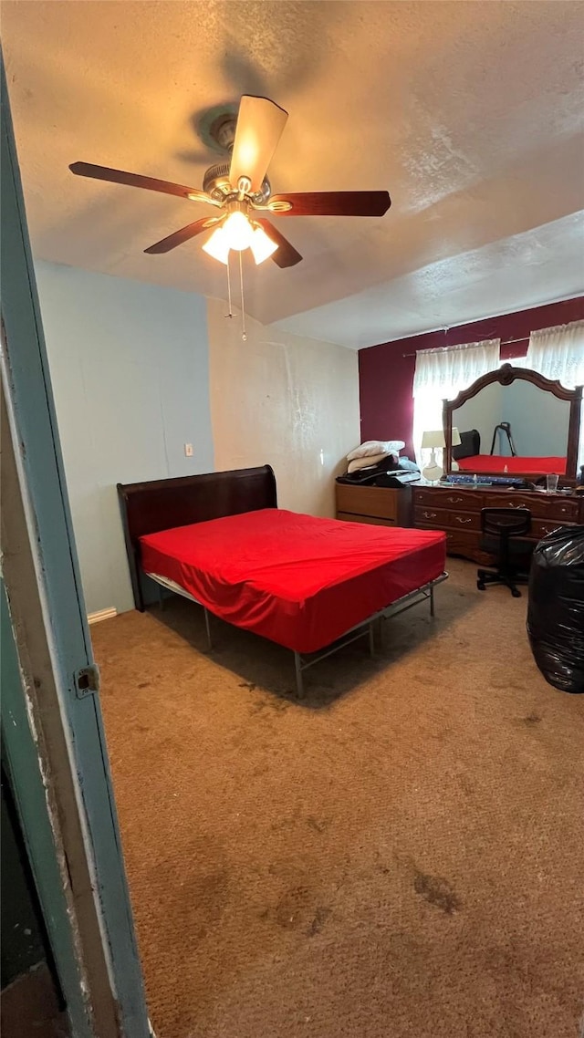 bedroom featuring ceiling fan, carpet flooring, and a textured ceiling