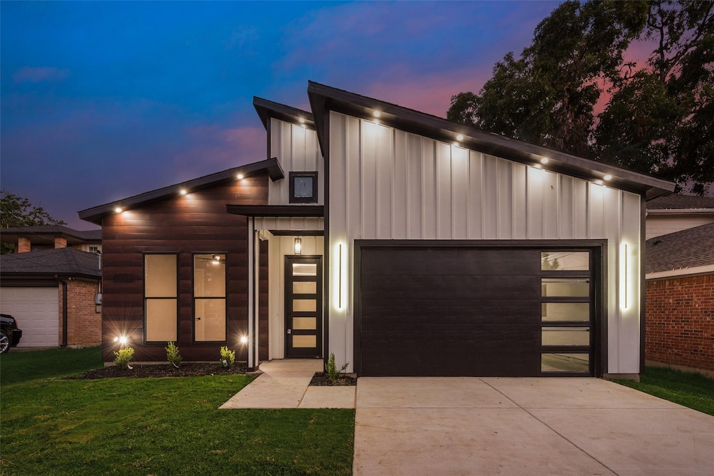 modern home featuring a garage and a yard