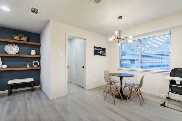 dining space with a notable chandelier and light hardwood / wood-style flooring