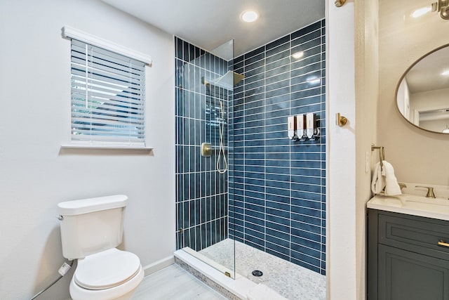 bathroom with vanity, toilet, and a tile shower