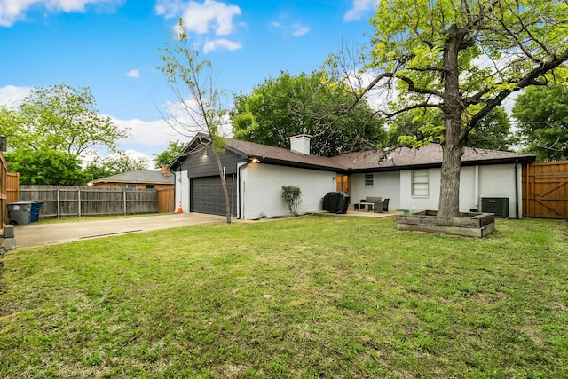 back of property with a garage, a lawn, and central air condition unit