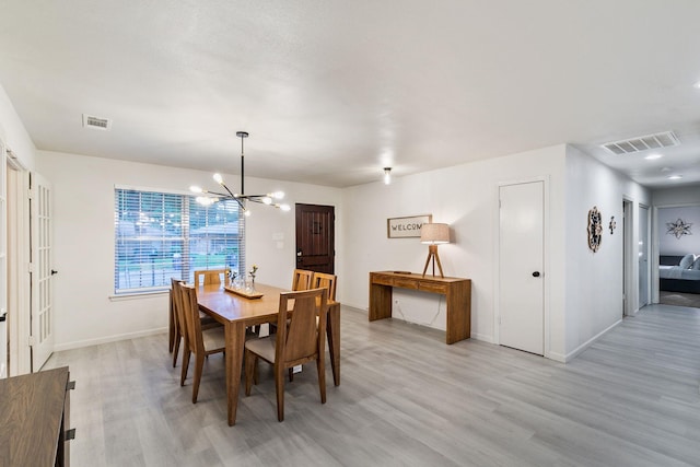 dining space featuring a chandelier and light wood-type flooring