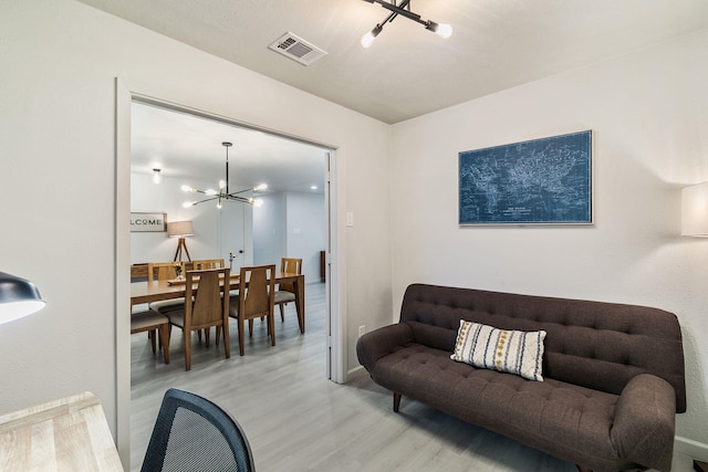 living room featuring a notable chandelier and light hardwood / wood-style flooring