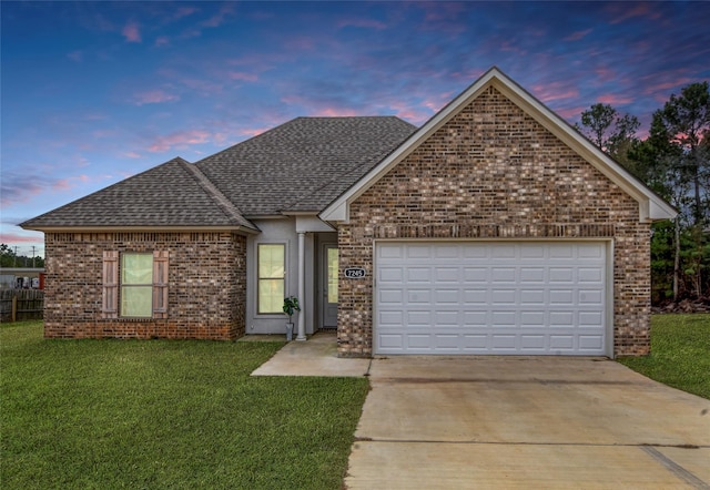 view of front of property with a garage and a yard