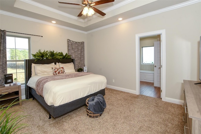 bedroom with ensuite bath, ceiling fan, carpet floors, ornamental molding, and a raised ceiling