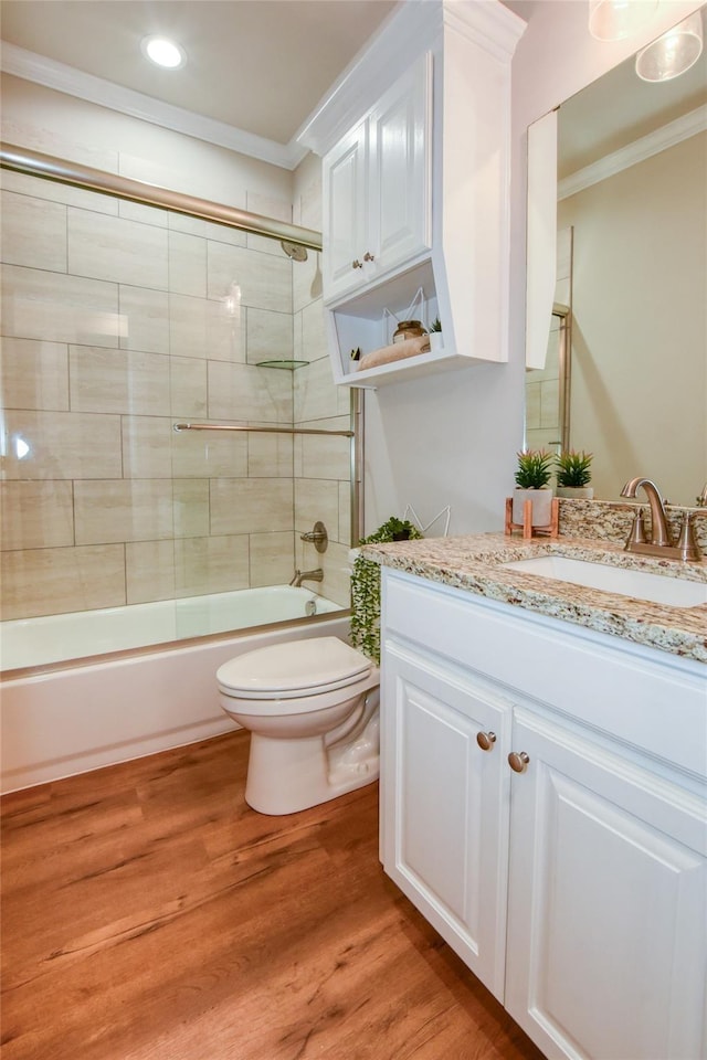 full bathroom featuring toilet, crown molding, bath / shower combo with glass door, vanity, and hardwood / wood-style floors