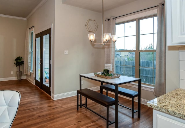 dining room featuring dark hardwood / wood-style flooring, crown molding, and french doors