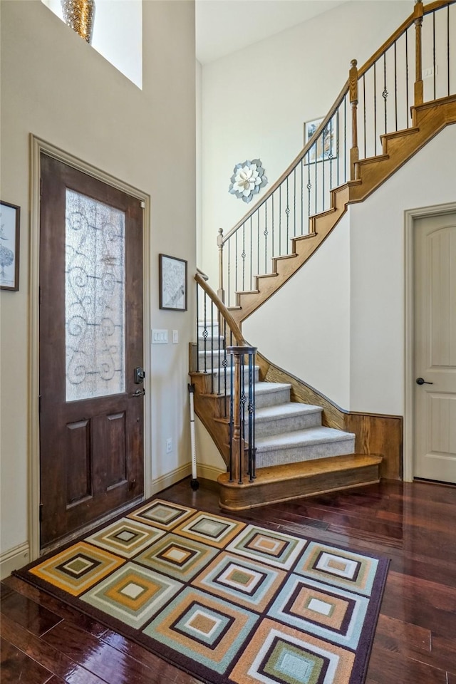 entryway with hardwood / wood-style flooring and a towering ceiling