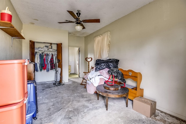 bedroom with ceiling fan, a closet, concrete floors, and a textured ceiling