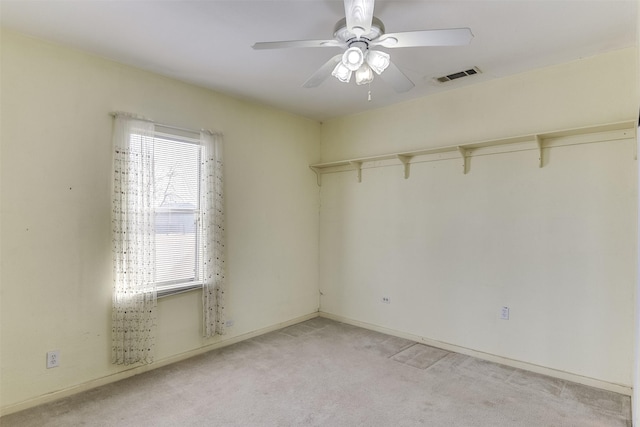 empty room featuring light colored carpet and ceiling fan