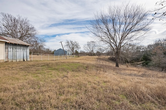 view of yard featuring an outdoor structure and a rural view