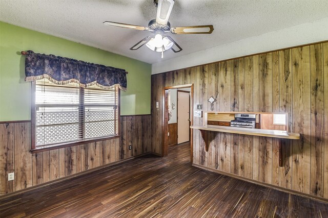 kitchen featuring sink, stainless steel gas range, white dishwasher, wood-type flooring, and a textured ceiling