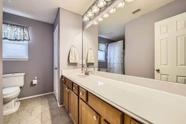 bathroom with vanity, a healthy amount of sunlight, tile patterned floors, and toilet