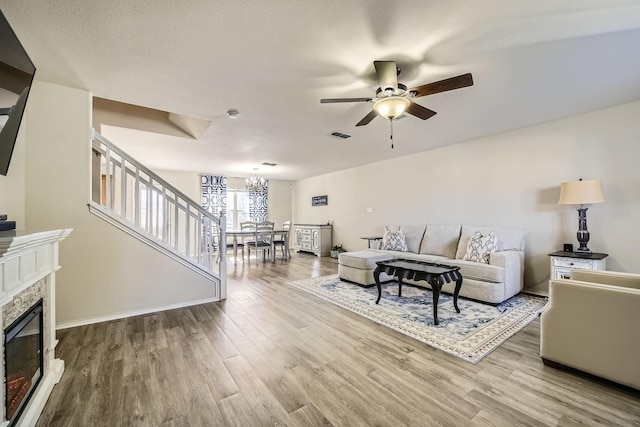 living room with wood-type flooring and ceiling fan with notable chandelier