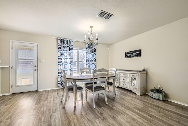 dining area featuring hardwood / wood-style floors and a chandelier