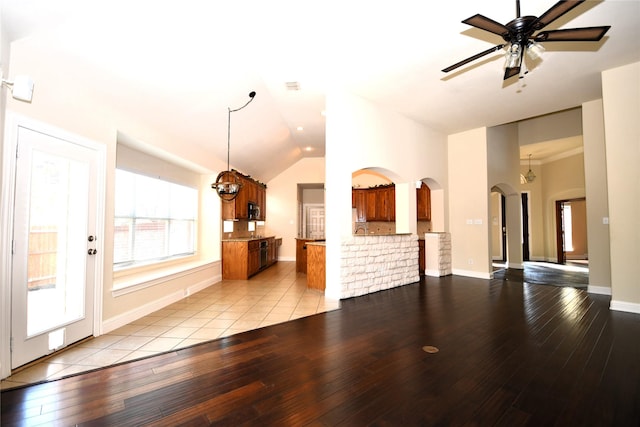 unfurnished living room with vaulted ceiling, ceiling fan, and light hardwood / wood-style flooring