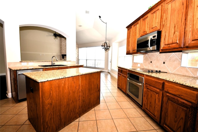 kitchen with sink, light tile patterned floors, a center island, and appliances with stainless steel finishes