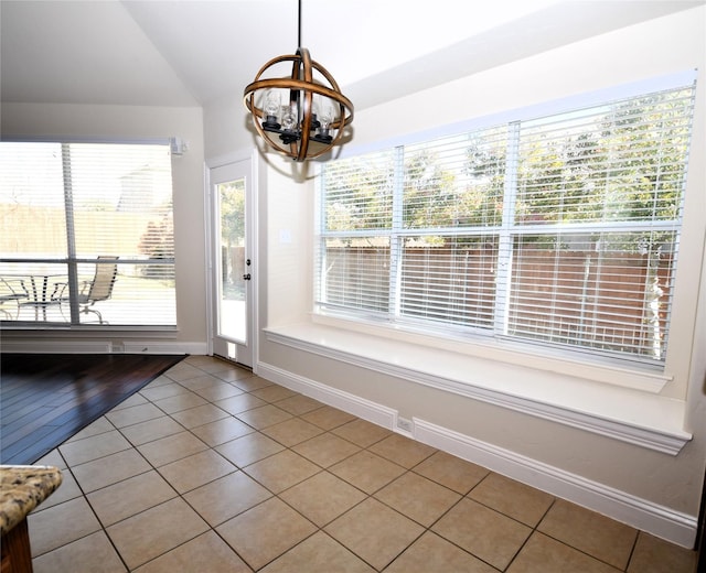 interior space featuring tile patterned flooring, a notable chandelier, and vaulted ceiling