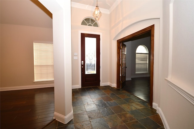 entryway featuring ornamental molding and an inviting chandelier