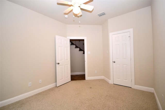 unfurnished bedroom featuring light colored carpet and ceiling fan