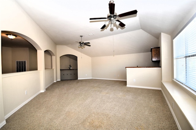 unfurnished living room featuring lofted ceiling, ceiling fan, and carpet flooring