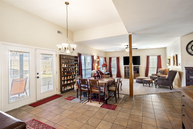 dining area featuring tile patterned flooring, ceiling fan with notable chandelier, and french doors