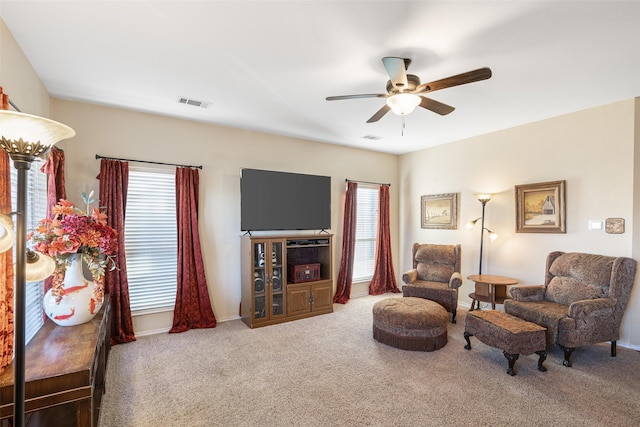 living area featuring carpet floors and ceiling fan