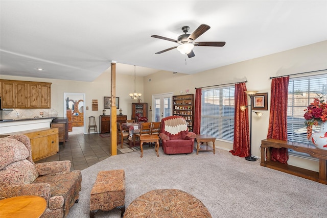 carpeted living room with ceiling fan with notable chandelier