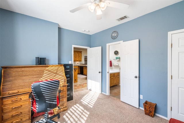 carpeted home office featuring ceiling fan