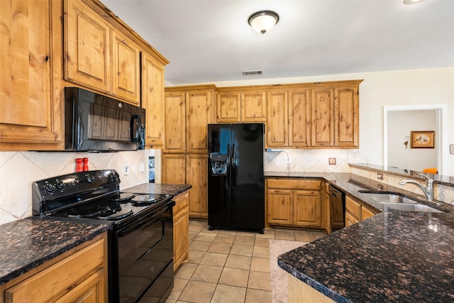 kitchen featuring sink, light tile patterned floors, black appliances, decorative backsplash, and dark stone counters