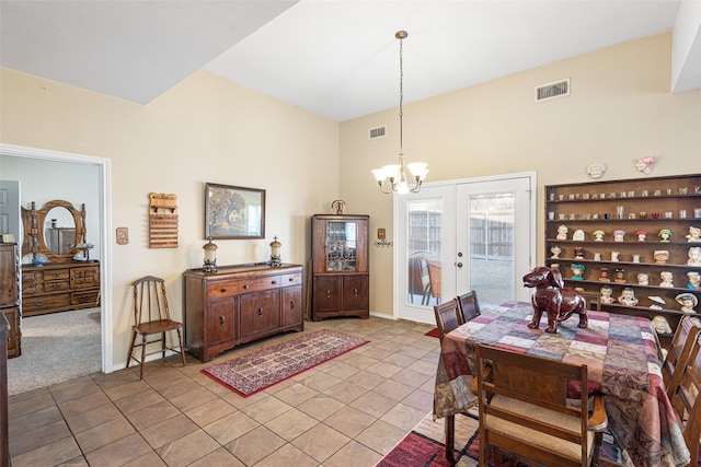 dining area featuring light tile patterned floors, a notable chandelier, and french doors