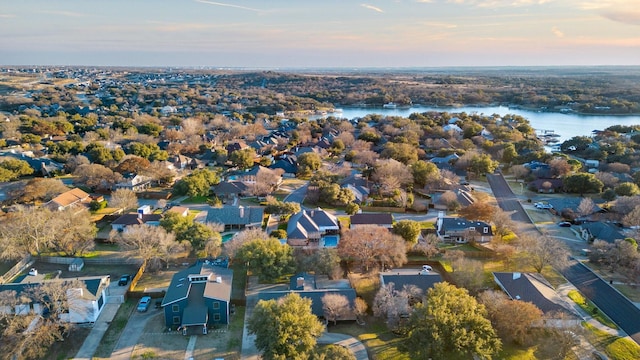 aerial view at dusk featuring a water view